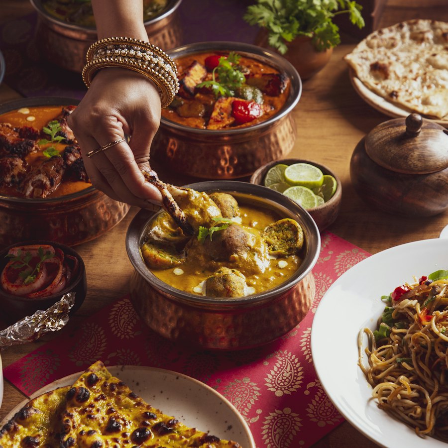 A grand wedding feast with curries served in copper pots